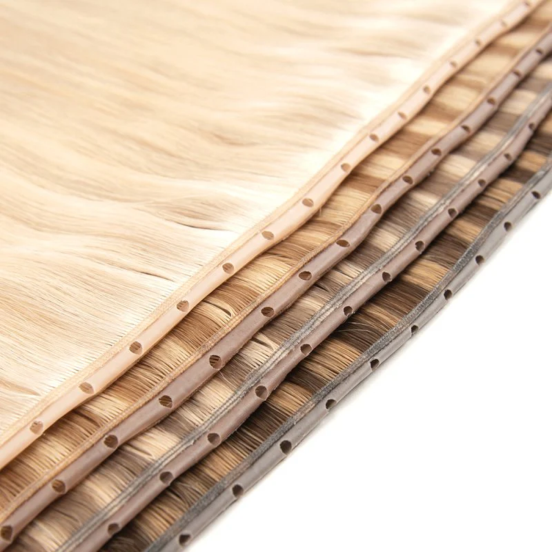 Products Extreme close-up of premium 100% virgin remy cuticle human hair butterfly weft extensions with pre-punched holes in blonde and brown shades for B2B wholesale salons and brands.